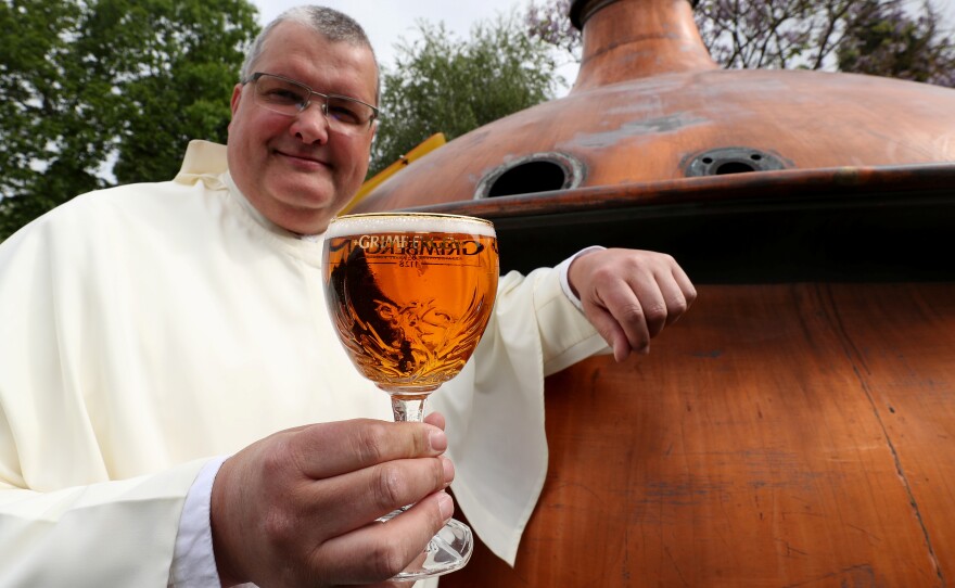 The Rev. Karel Stautemas poses with a Grimbergen beer in the courtyard of the Belgian Abbey of Grimbergen. Karel says the abbey's fathers will return to brewing after a break of two centuries.