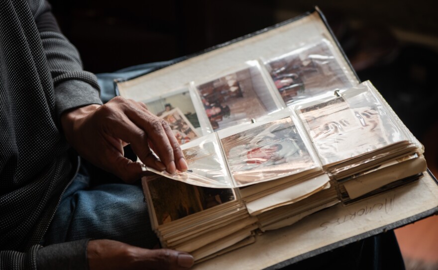 Calvin Neal looks through a photo album on Friday, Oct. 3, 2025. He carried the album on his back through the years he lived on the streets.
