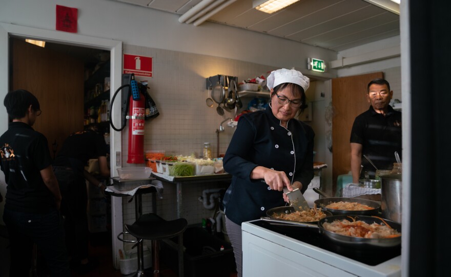 Siripen Paprajong, Suriya's wife, cooks in the kitchen of the restaurant.