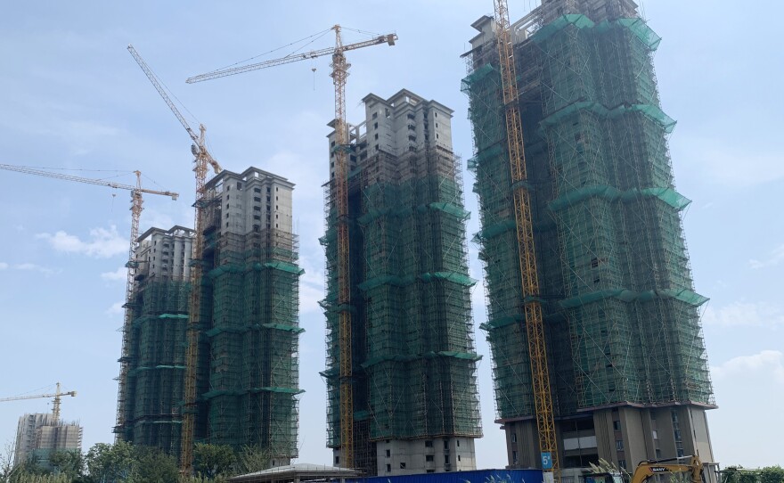 Half-finished apartment towers are part of Evergrande's Taicang Cultural City real estate project. The firm has run out of money to finish the buildings as regulators force developers to pay back debts.