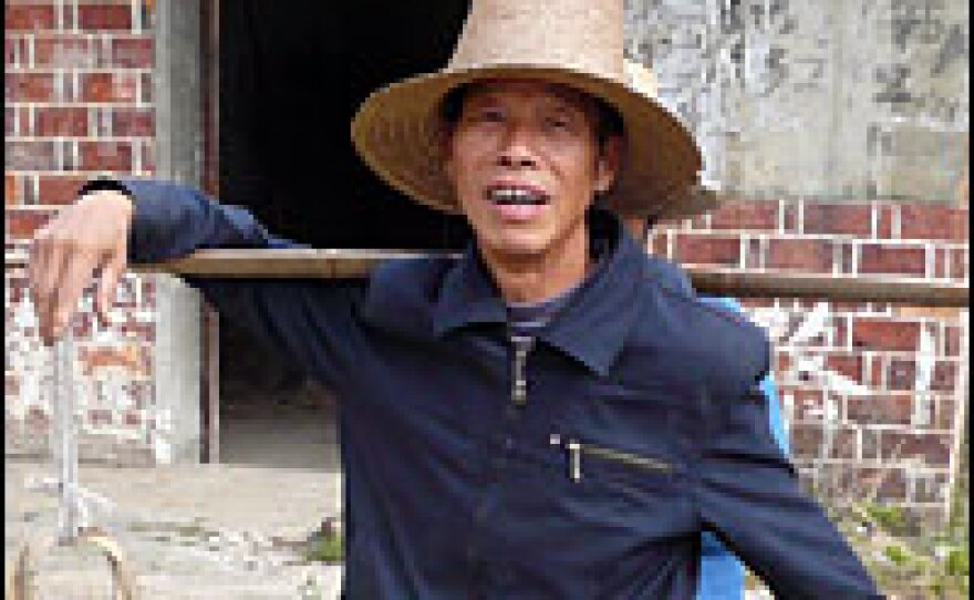 Zhang Shilin, 64, grows vegetables.   He believes farmers will never get rich until they lease out their plots to professionals.