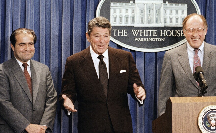 In this June 17, 1986, file photo, President Ronald Reagan speaks at a news briefing at the White House in Washington, where he announced the nomination of Antonin Scalia (left) to the Supreme Court.