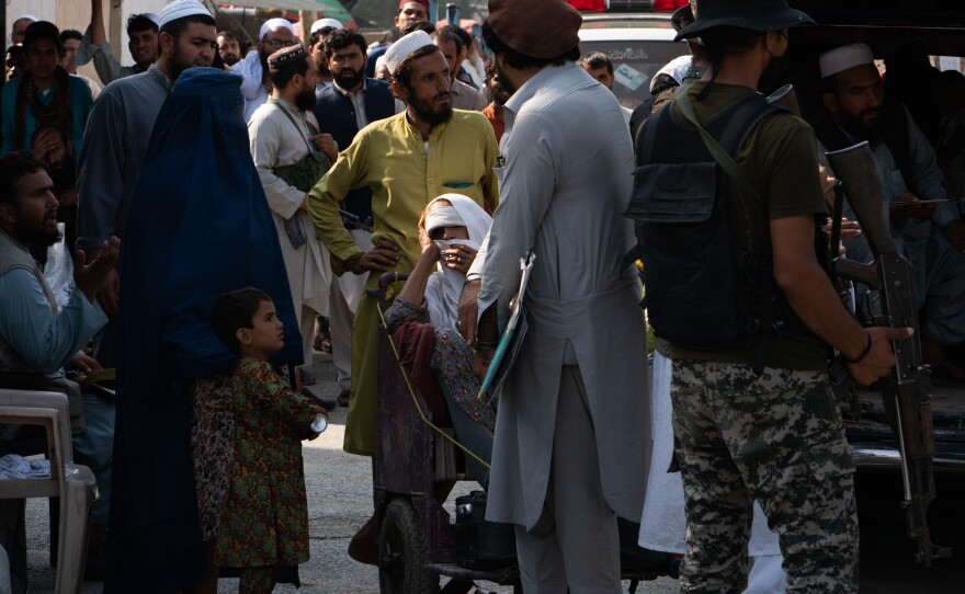 People seeking medical attention wait on the border to enter Pakistan.