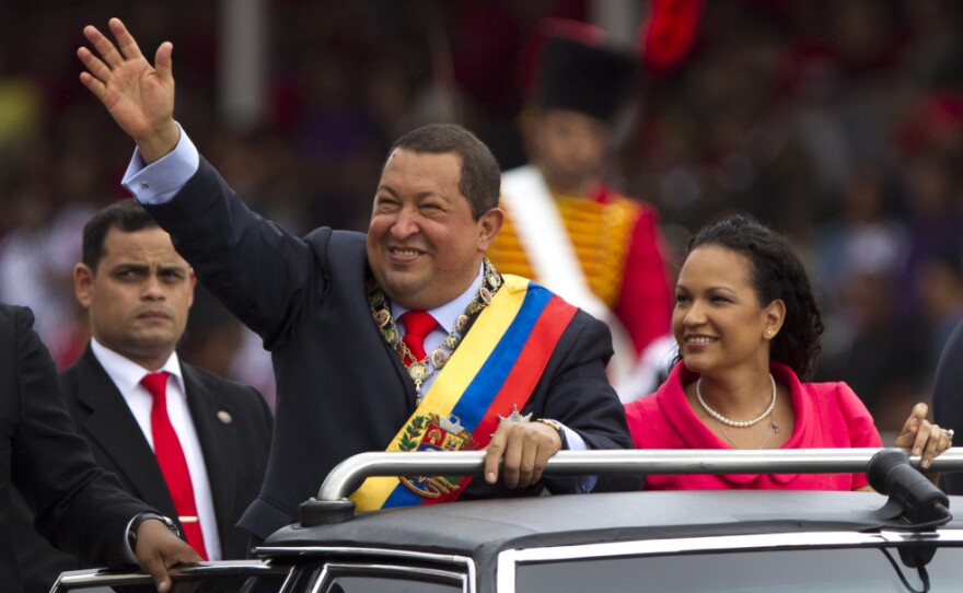 Chavez waves next to his daughter, Rosa Virginia, during a military parade in Caracas in February 2012, commemorating the 20th anniversary of the failed coup attempt that launched his political career.