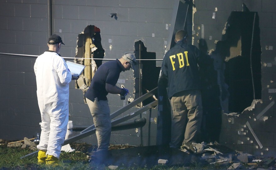 FBI agents inspect the rear wall of the Pulse Orlando nightclub in Orlando, Fla., where authorities say 49 victims died Sunday. The gunman, identified as Omar Mateen, was killed by police.