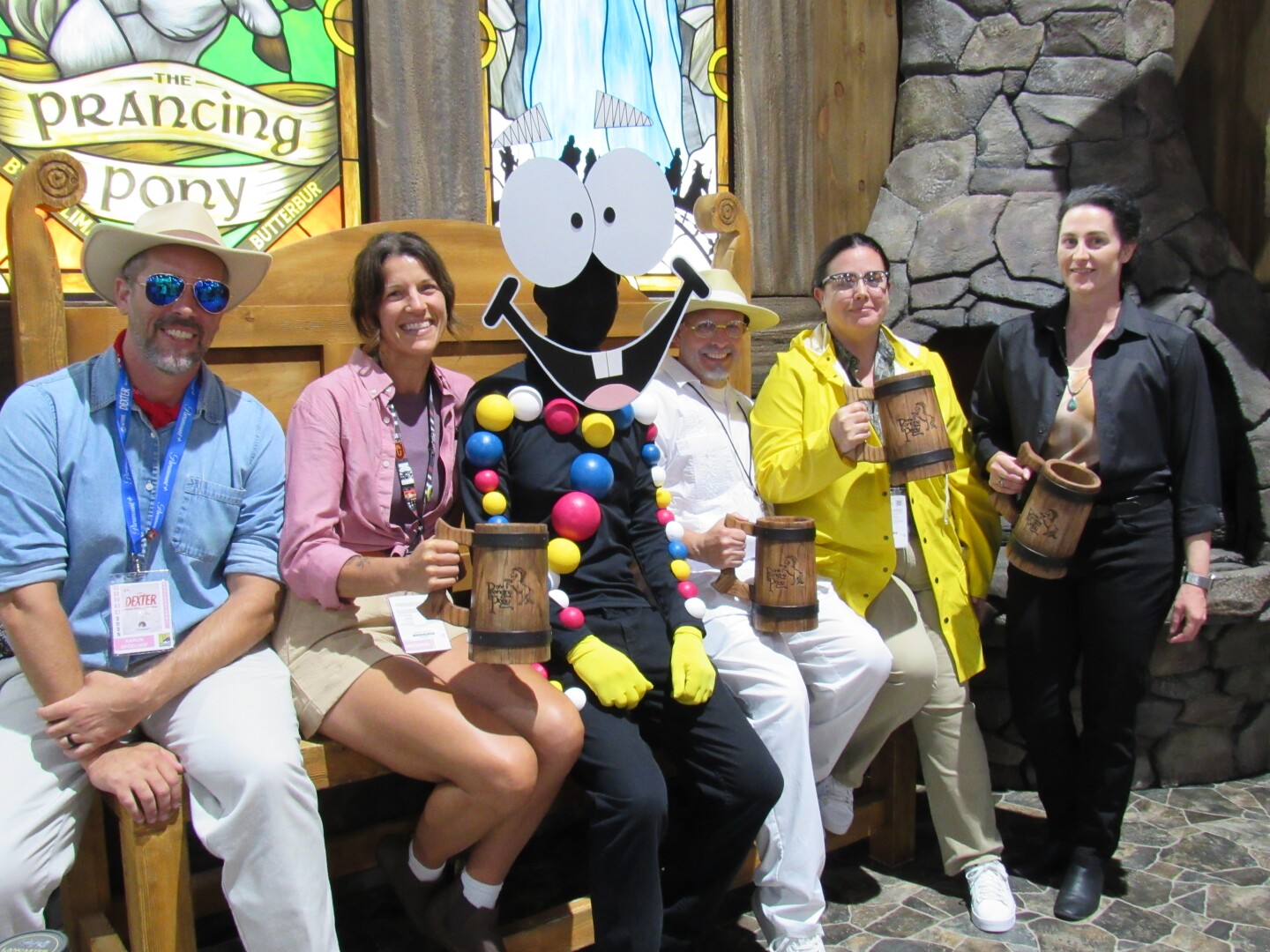 Comic-Con attendees dressed as cast members from "Jurassic Park" smile with "Lord of the Rings" swag at the San Diego Convention Center on July 26, 2025.