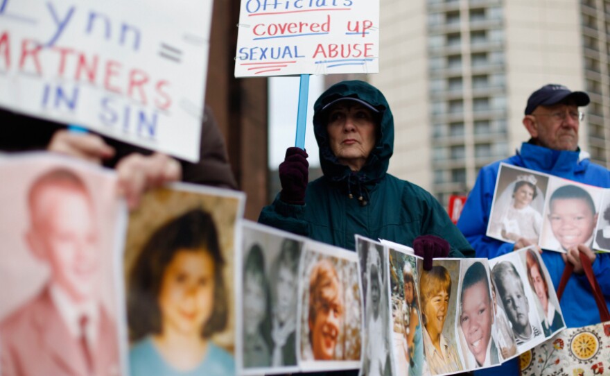 Catherine Coleman Murphy, of Lansdale, Pa., and Jack Wintermyer, of Silver Spring, Md., protest outside Cathedral Basilica of Saints Peter and Paul in Philadelphia the day after the Philadelphia archdiocese suspended 21 priests who were named by a grand jury as child molestation suspects.