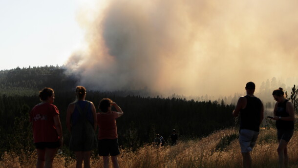 People watch Old Trails Fire from W. Northwest Blvd., Saturday, Aug. 1, 2026, in Spokane, Wash.