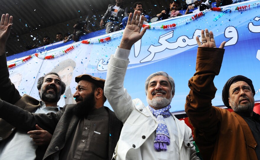 Afghan presidential candidate Abdullah Abdullah (center) and his vice presidential candidates Mohammed Mohaqiq (right) and Mohammad Khan (left) wave to their supporters at a rally in the northwestern city of Herat in April.