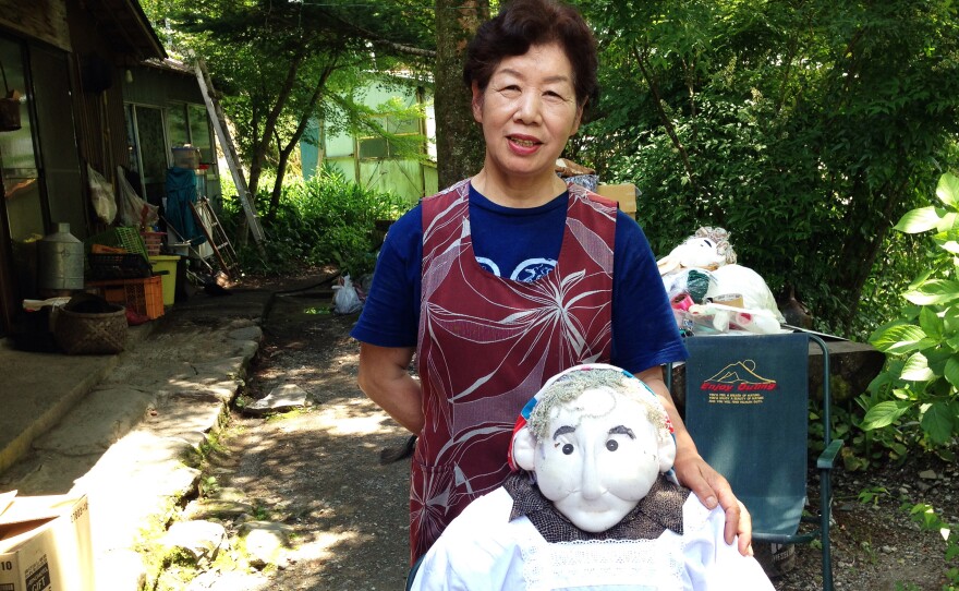 Tsukimi Ayano, 67, stands in front of her house with one of her scarecrow figures. She estimates that she's made around 400 scarecrows.