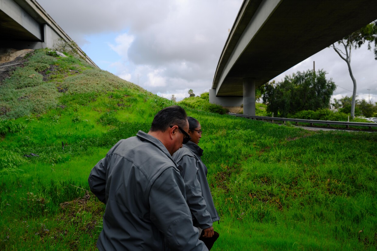 Qiana Williamson and Hector Hueso, the two members of National City’s HOME team, walk along a section of the I-5 freeway on March 7, 2024. National City is the second in San Diego County to move away from a police-led response to homelessness and toward trained caseworkers.