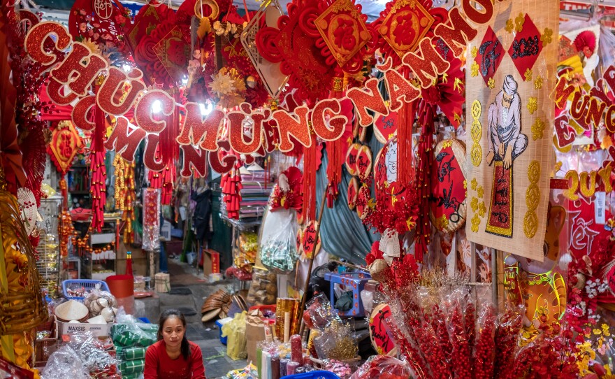 Sitting among Lunar New Year decorative items, a vendor waits for customers at her shop in Hanoi on Jan. 14.