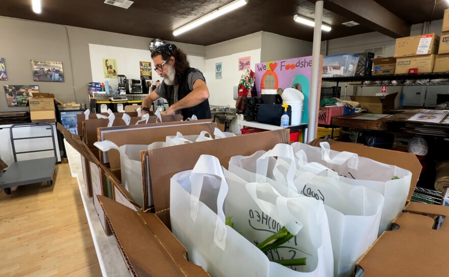 A worker is shown loading food into bags at the Foodshed Cooperative on Jan. 3, 2024.