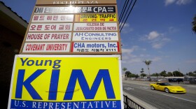 In this Wednesday, Oct. 10, 2018, file photo a campaign poster for Young Kim, a Republican running for a U.S. House seat in the 39th District in California, hangs on a building sign advertising in multiple languages in Fullerton, Calif. Kim lost to Democrat Gil Cisneros. Orange County's Registrar of Voters reports Wednesday, Aug. 7, 2019, there are 89 more Democrats than Republicans among its 1.6 million registered voters. 