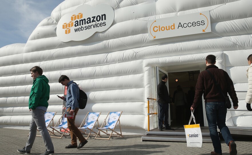 Visitors arrive at the cloud pavilion of Amazon Web Services at the 2016 CeBIT digital technology trade fair on March 14, 2016 in Hanover, Germany.