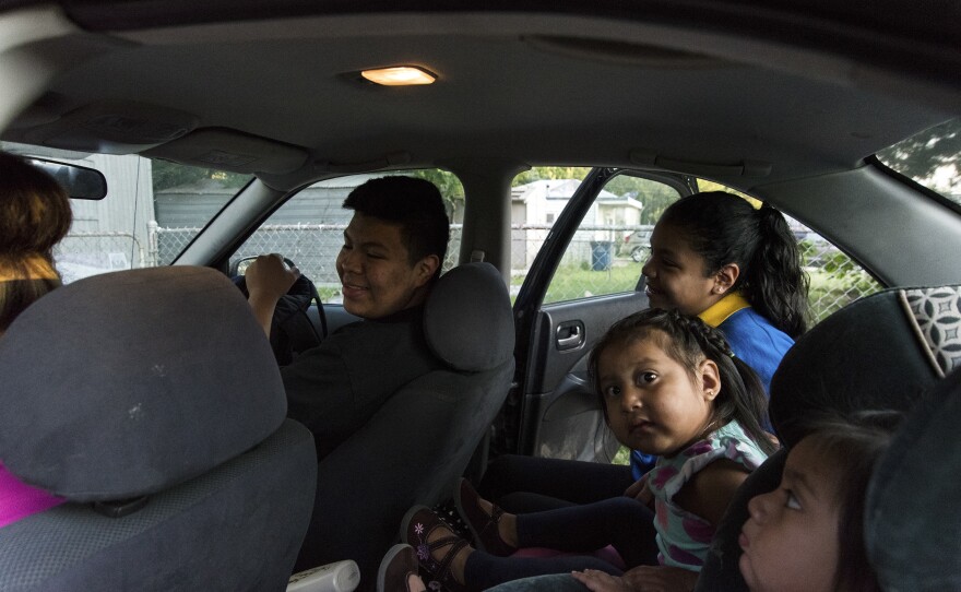 Jose Arriaga gets settled into the passenger seat of his mother Veronica's car. Veronica will make three stops that morning dropping off Jose first, then his sisters.