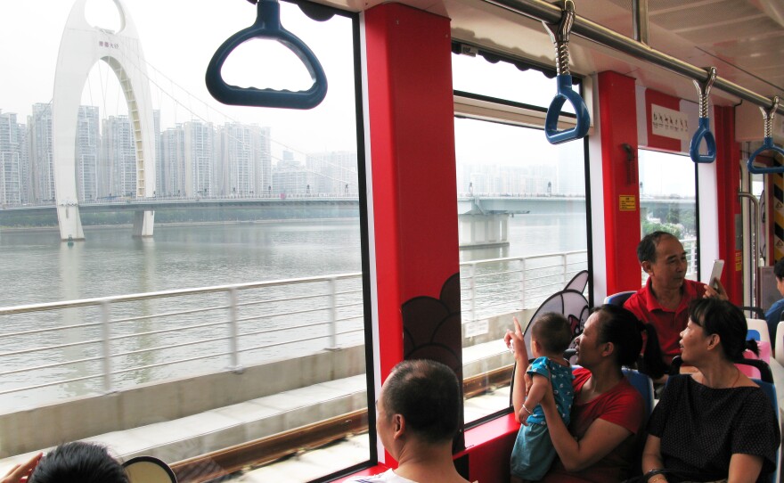 Streetcar passengers look out the window at Guangzhou's Pearl River.