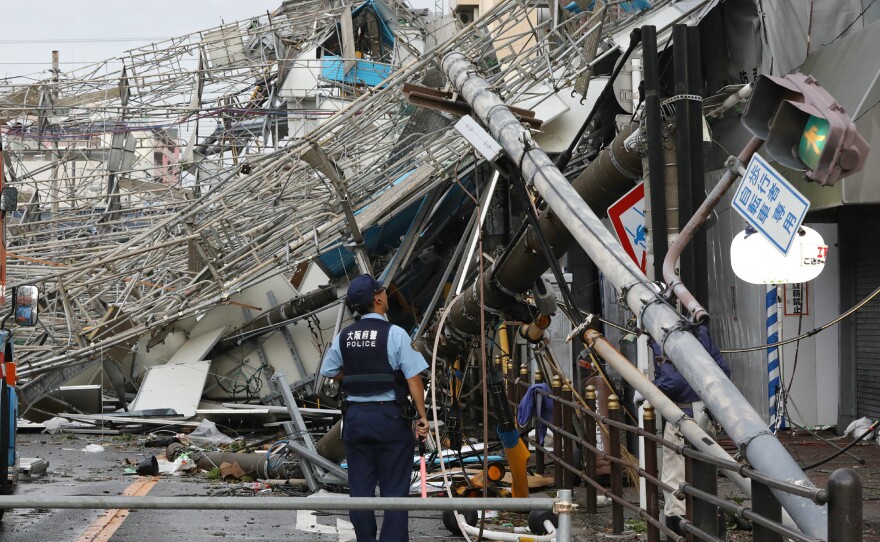 Damaged traffic boards and telecommunication relay poles are seen after they were brought down by strong winds caused by typhoon Jebi in Osaka on Tuesday.
