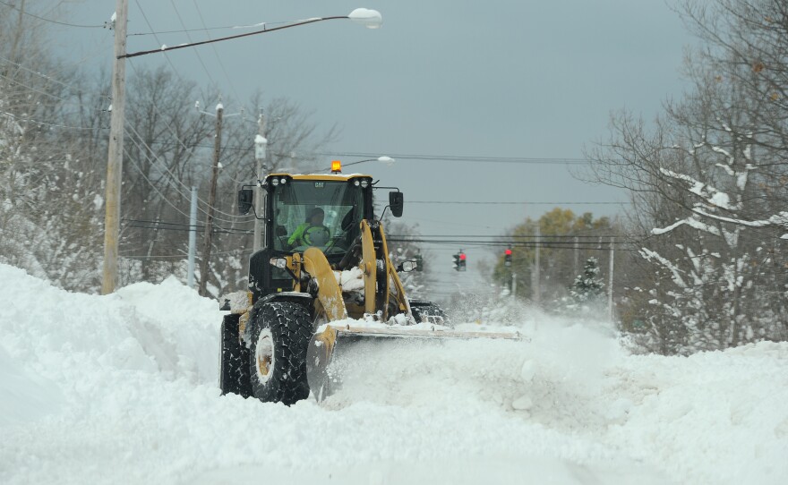A National Guard loader clears a road after an intense lake-effect snowstorm impacted the area on Saturday in Hamburg, New York.