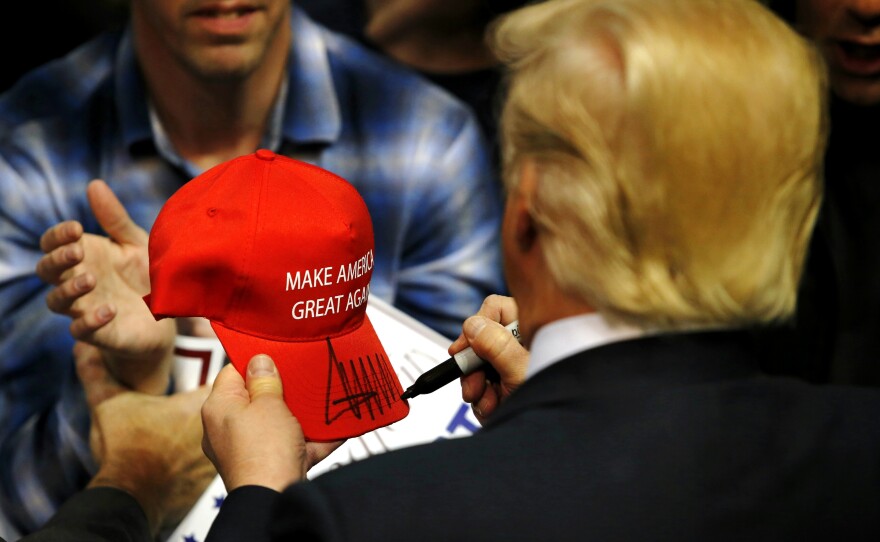 Republican presidential candidate Donald Trump signs a hat for a supporter after speaking at a campaign rally on April 11, 2016 in Albany, N.Y.