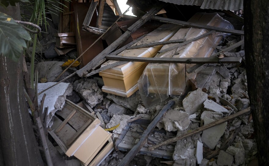 <strong data-stringify-type="bold">Mon., Aug. 16: </strong>Coffins lay in the debris of a collapsed store that sold coffins in Saint-Louis-du-Sud, Haiti.