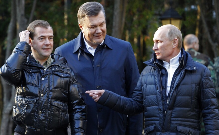 Ukrainian President Viktor Yanukovich (center) meets with Russian leaders Dmitry Medvedev (left) and Vladimir Putin outside Moscow in 2011. Yanukovich had warm relations with Russia, but was ousted amid mass protests in February 2014. Shortly afterward, Putin sent Russian troops into Ukraine, where they seized Crimea.