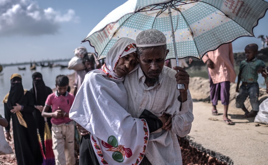 Nur Nahar, 40, a Rohingya refugee suffering from tuberculosis, clings to her husband, Bashir Ullah, 50, after arriving in Bangladesh.
