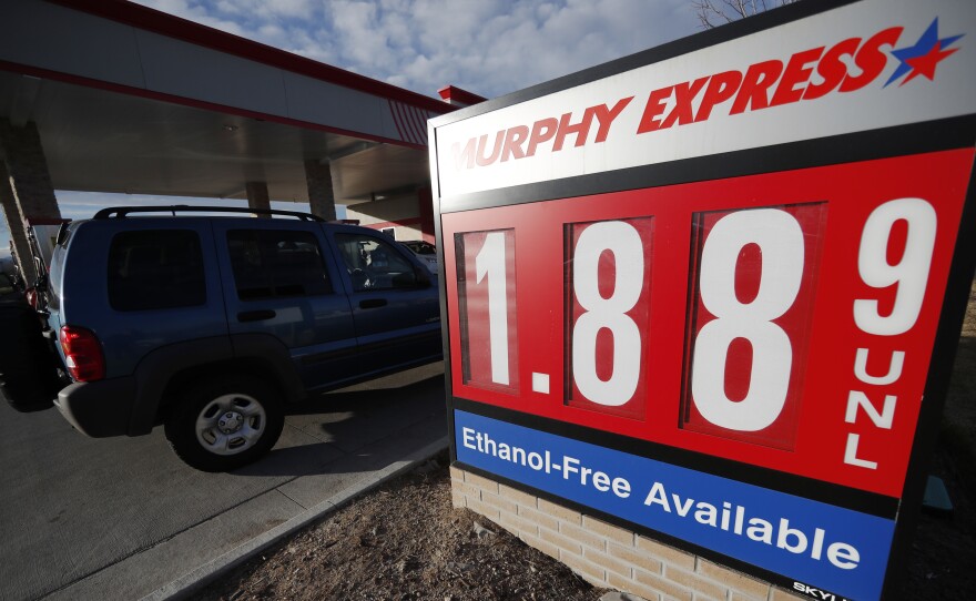 Motorists drive past a sign advertising regular gasoline at $1.88 per gallon at a station in Longmont, Colo., on Dec. 22, 2018. Falling gasoline prices have given drivers a little extra cheer this winter.