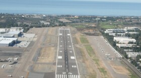 The landing strip at McClellan-Palomar Airport in Carlsbad, CA. The runway expansion would be built on the eastern end, which is covered in green grass in this photo. 