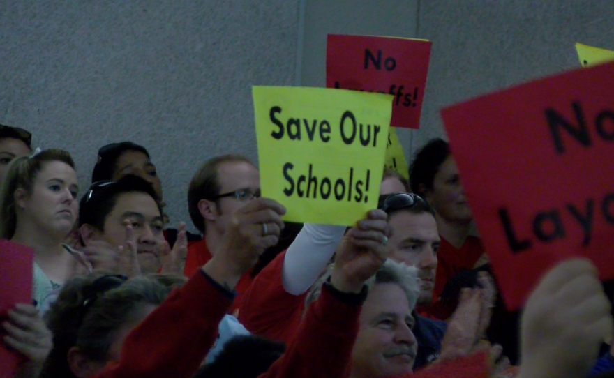 Parents and educators hold signs reading, "Save Our Schools," at a San Diego Unified School Board meeting, Feb. 21, 2017.