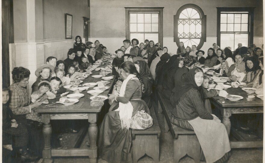 An early-20th century photo by Edwin Levick, "Uncle Sam, host. Immigrants being served a free meal at Ellis Island," is part of the NYPL's photography collection.