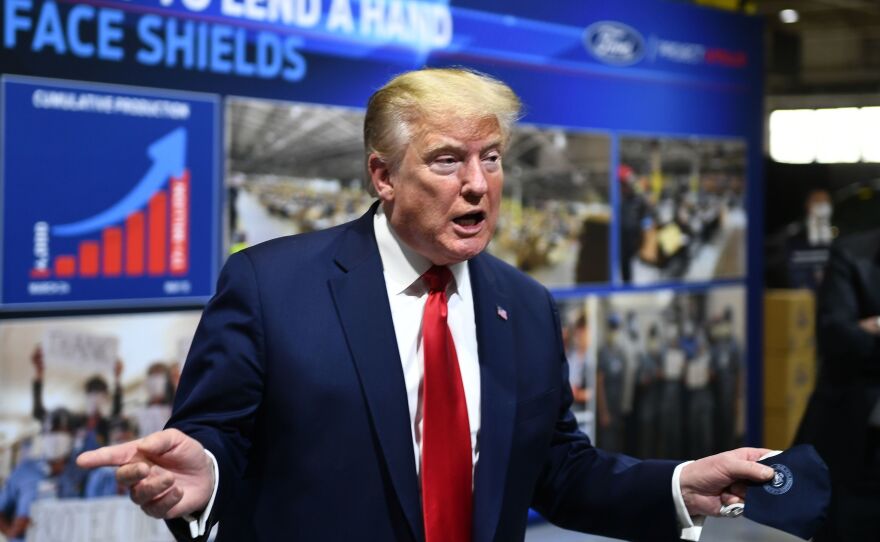 President Trump holds a mask as he speaks during a tour of the Ford Rawsonville Plant in Ypsilanti, Mich., on Thursday.
