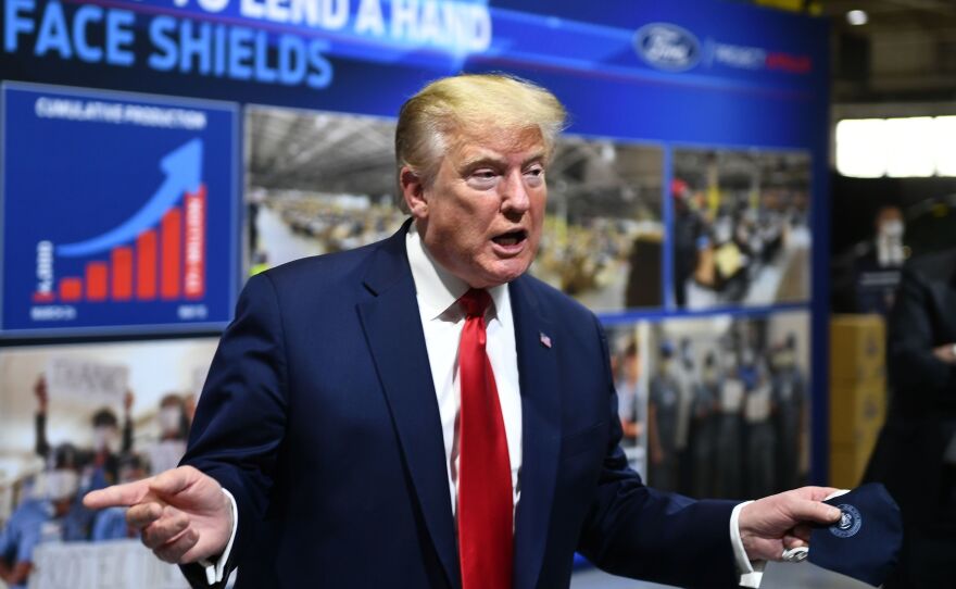 President Trump holds a mask as he speaks during a tour of the Ford Rawsonville Plant in Ypsilanti, Mich., on Thursday.