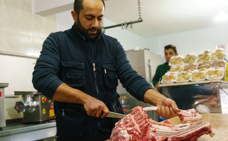 Abu Mohammed, the owner of Sultan Kesap restaurant in the Southern Turkish city of Reyhanli, debones a lamb for meat. His butcher shop/eatery provides his displaced countrymen with culinary reminders of home during better days.