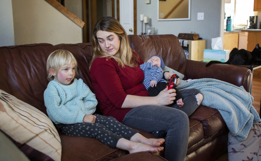 Amber Gorrow and her daughter, Eleanor, 3, pick out a show to watch after Eleanor's nap at their home in Vancouver, Wash., on Wednesday. Eleanor has gotten her first measles vaccine, but Gorrow's son, Leon, 8 weeks, is still too young to be immunized.