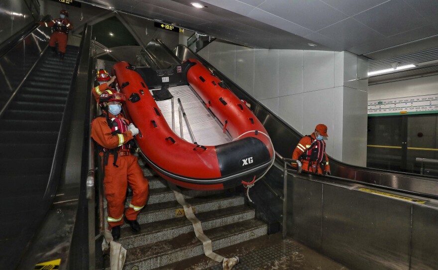 Rescuers carry a boat into the subway in Zhengzhou, China, in July after flash floods trapped passengers underground.