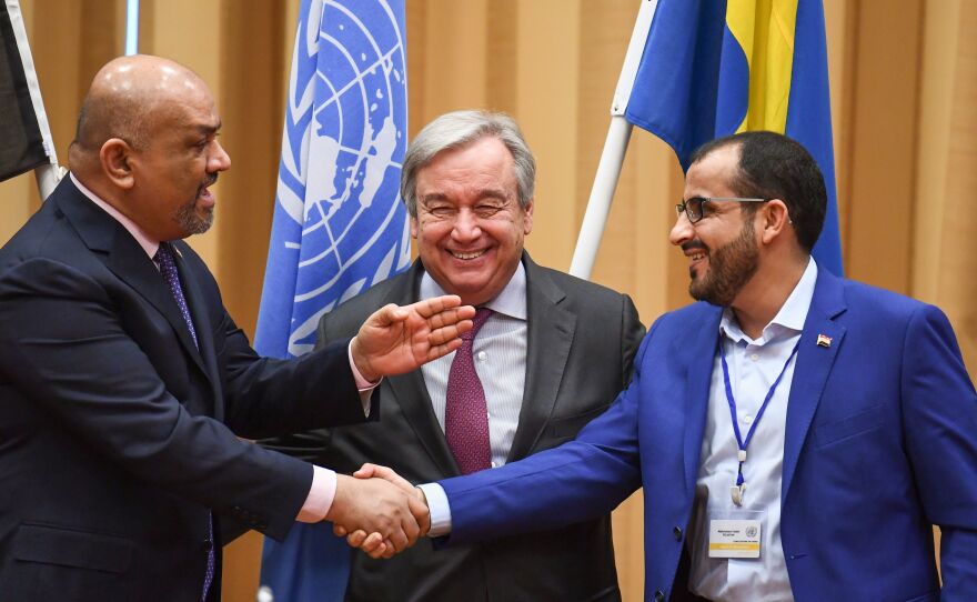 Yemeni Foreign Minister Khaled al-Yamani (left) and head rebel negotiator Mohammed Abdelsalam (right) shake hands under the eyes of U.N. Secretary-General António Guterres, during peace talks Thursday at Johannesberg Castle in Rimbo, Sweden.