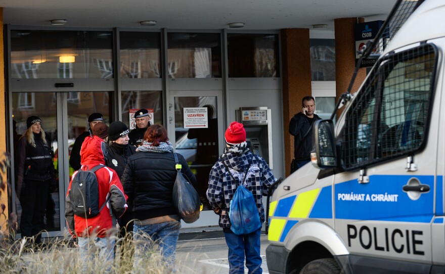 Police officers guard the doors of a teaching hospital in Ostrava, Czech Republic, after a gunman carried out a mass shooting in its waiting room Tuesday morning.