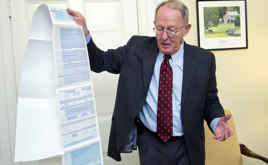 Sen. Lamar Alexander, R-Tenn. holds the Free Application for Federal Student Aid (FAFSA). Alexander is pushing to shorten the 108-question form to just two questions.