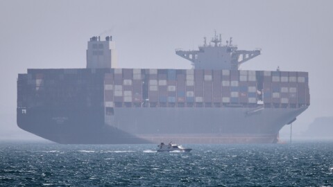 A container ship sits at anchor as a small motorboat passes in the foreground in the Strait of Hormuz off Bandar Abbas, Iran, on May 2.