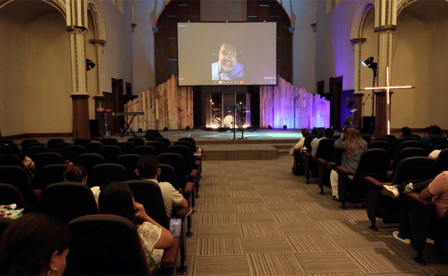 The Rev. Esdras Paredes is projected on a screen, while preaching remotely from Guatemala, during a Ven y Descansarás Church service in Fond du Lac, Wis.