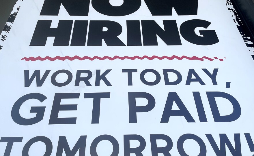 A 'Now Hiring' sign is displayed at a fast food chain on June 23 in Los Angeles. Businesses are eager to hire but they are struggling to find workers because of a number of factors, including difficulties in finding child care or fears about getting infected.