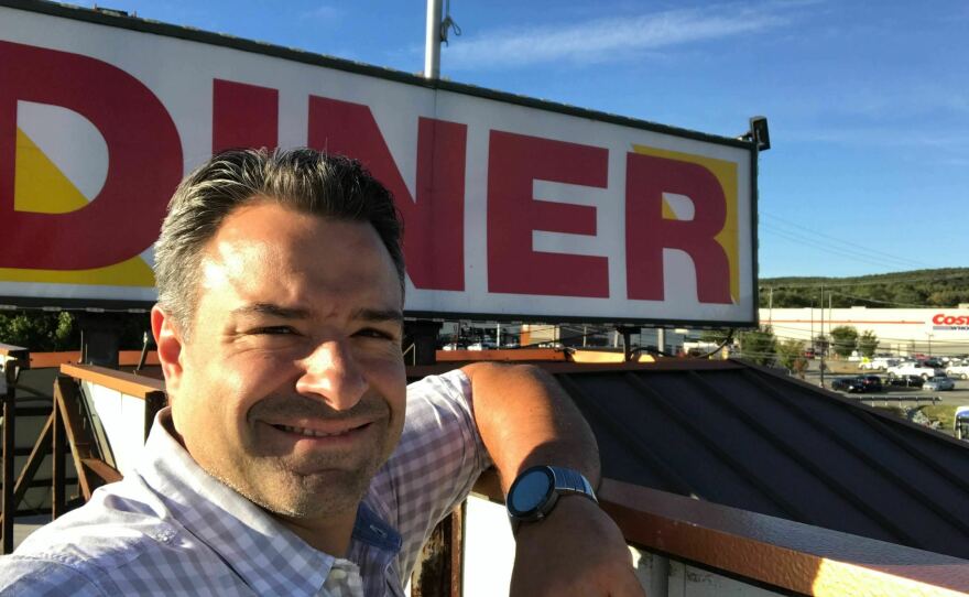 Peter Sedereas in front of the Townsquare Diner sign in 2021.