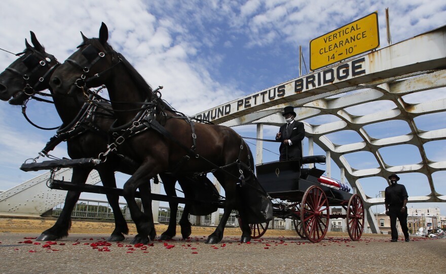 The casket of Rep. John Lewis moves over the Edmund Pettus Bridge by horse drawn carriage during a memorial service for Lewis, Sunday, July 26, 2020, in Selma, Ala.