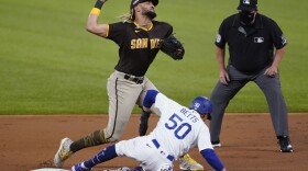 Los Angeles Dodgers' Cody Bellinger slams into the outfield wall and makes the catch as he robs San Diego Padres' Fernando Tatis Jr. of a home run on a deep drive during the seventh inning in Game 2 of a baseball National League Division Series Wednesday, Oct. 7, 2020, in Arlington, Texas. 