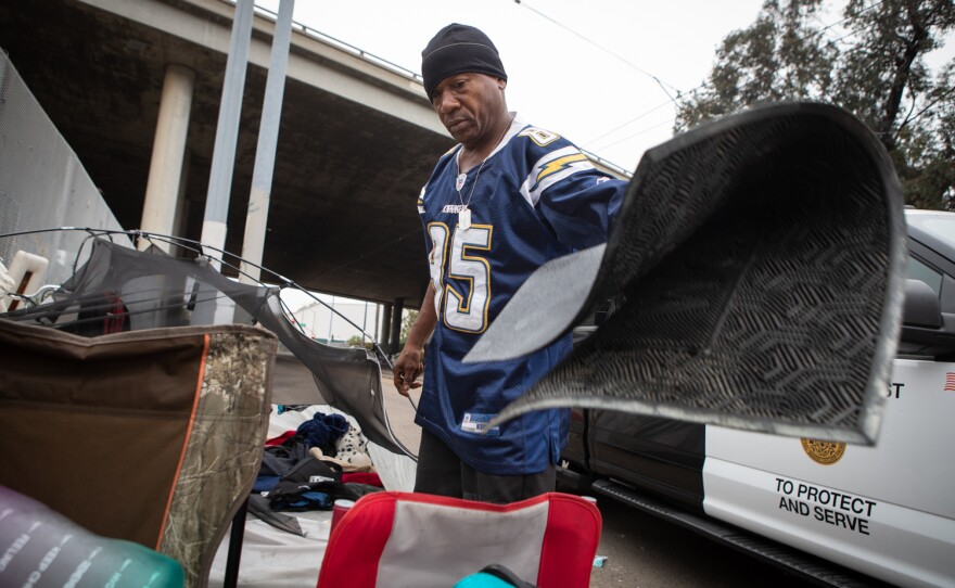 Warren Zevon Riddle packs up his belongings during an enforcement sweep on Commercial Street in San Diego, June 9, 2022. He plans to move to Market Street.