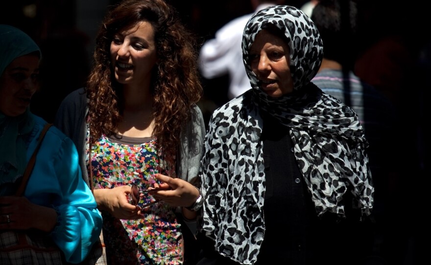 Tunisian women walk through the narrow streets of Tunis' medina, or marketplace. Compared to women in other Arab countries, Tunisian women have had access to education and job opportunities for decades.
