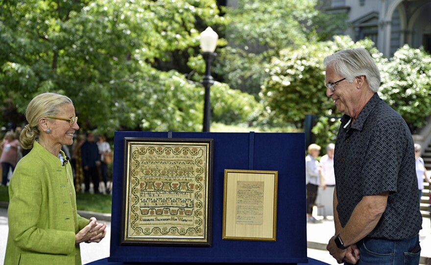 Nancy Druckman (left) appraises a 1788 Elizabeth Shoemaker needlework sampler at Crocker Art Museum. 