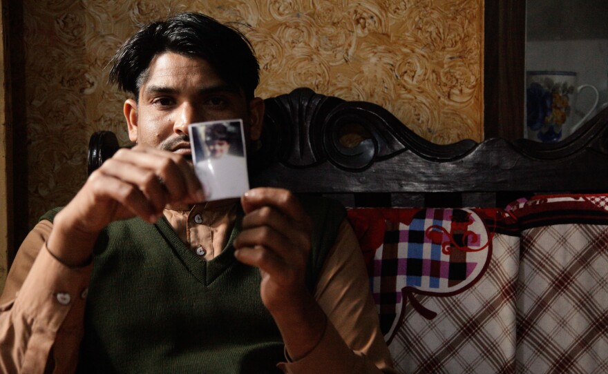 Mustafa, a barber in Kasur, holds the only image he has of his daughter, Noor-Fatima. About a year ago, he sent the 6-year-old to buy milk. She was found the next day, raped and killed, her body dumped in a construction site.