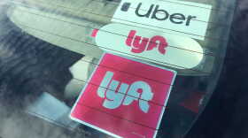 Uber and Lyft stickers are visible in the rear windshield of a car, Nov. 5, 2020.